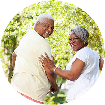 black elderly couple looking over their shoulders and smiling at the camera