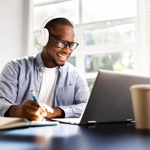 A smiling young man taking an HR training course online