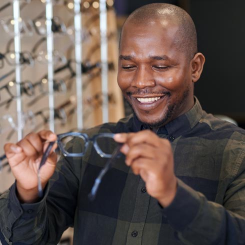 Man holding his new glasses and smiling